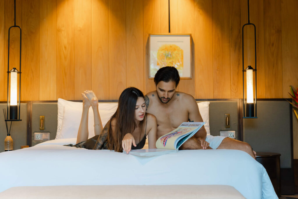 Couple reading together on the bed at a Bali resort villa