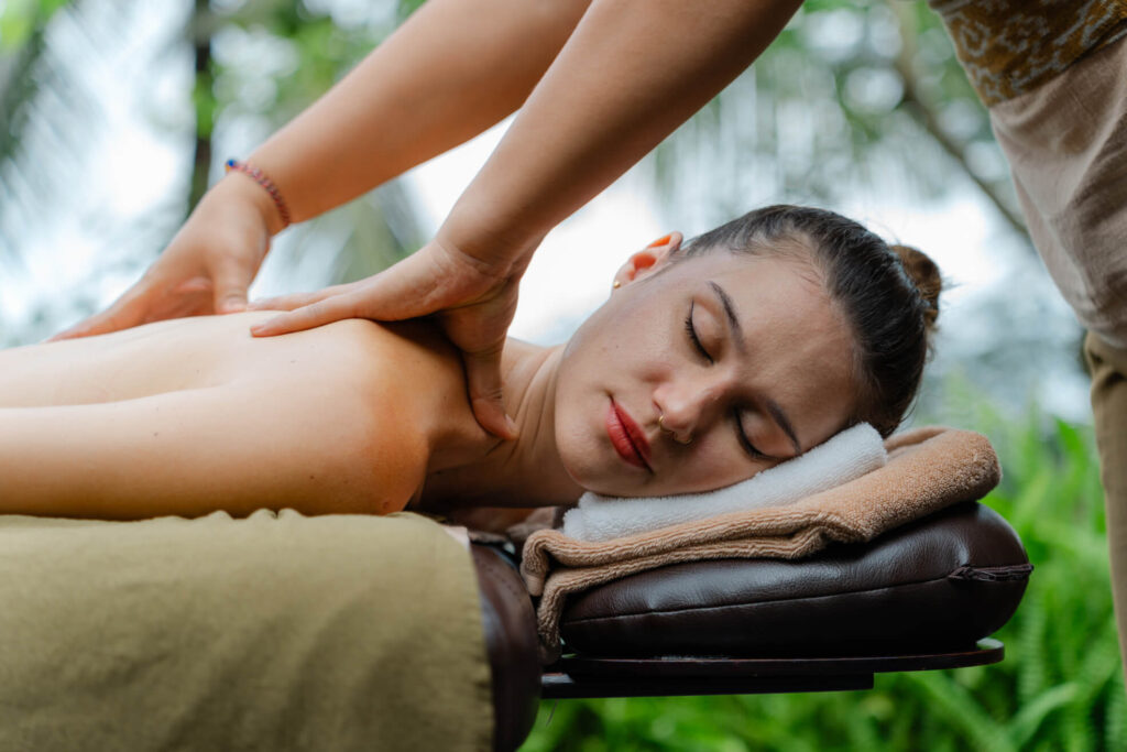 Close-up of woman enjoying facial massage at The Ridge Ubud outdoor spa