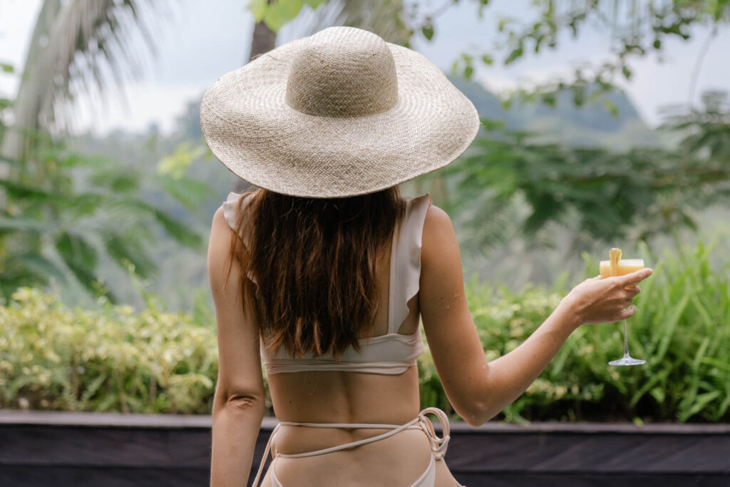 Woman in swimsuit enjoying a cocktail at a tropical Bali villa